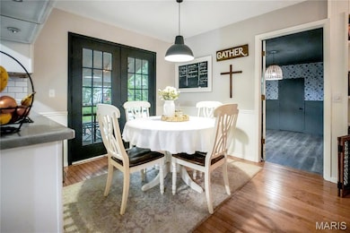 Dining space with hardwood / wood-style flooring, french doors, and wainscoting