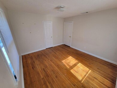 Unfurnished room with a textured ceiling and wood-type flooring