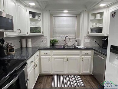 Kitchen featuring white cabinets, a sink, stainles