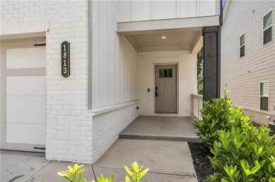Property entrance with board and batten siding, brick siding, and a garage