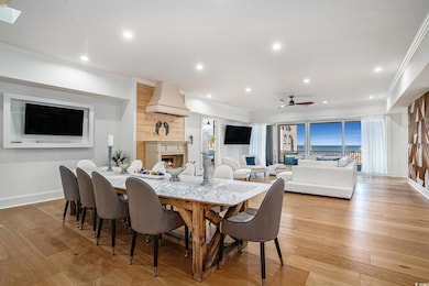 Dining area with crown molding, a large fireplace, baseboards, a ceiling fan, and recessed lighting