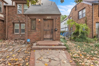 Property entrance with brick siding and a shingled roof