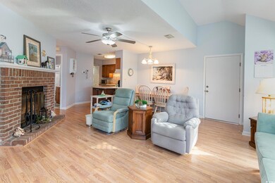 Living area featuring a fireplace, lofted ceiling,