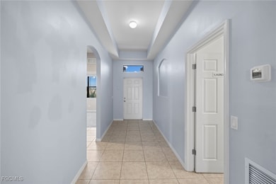 Hallway with arched walkways and light tile patter