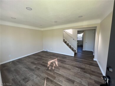 Empty room with dark hardwood / wood-style floors and a textured ceiling