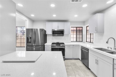 Kitchen featuring light stone counters, recessed l