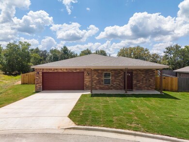 Ranch-style home with a front yard, an attached g