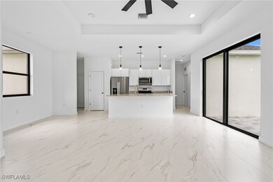 Unfurnished living room featuring light marble finish floors, recessed lighting, a raised ceiling, and ceiling fan