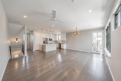 Unfurnished living room featuring dark hardwood / wood-style flooring and ceiling fan with notable chandelier