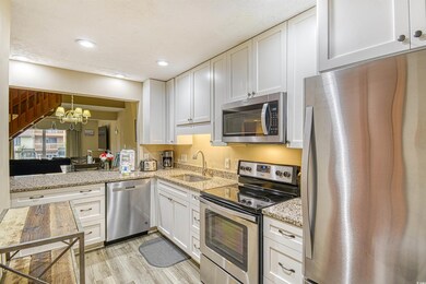 Kitchen with sink, white cabinets, light hardwood 