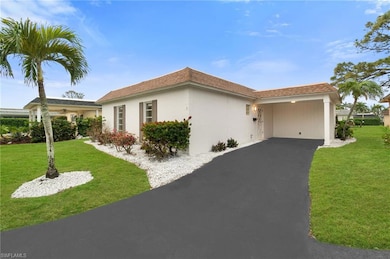 View of front of property featuring a carport and a front lawn