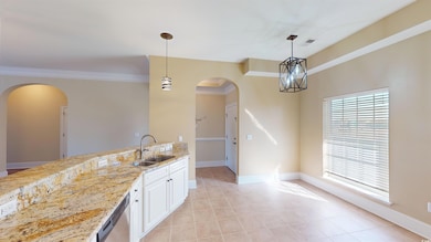 Kitchen featuring light stone counters, dishwasher