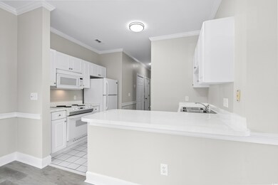 Kitchen featuring white appliances, white cabinets