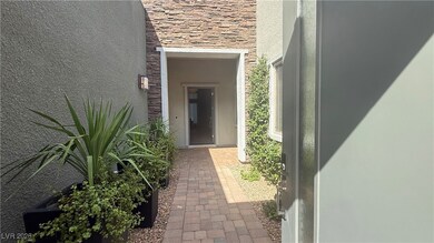 Property entrance featuring stucco siding and ston