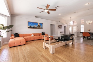 Living room with lofted ceiling, light wood-style