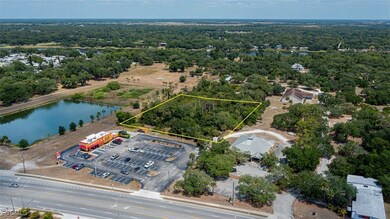 Aerial view of property's location with property parcel outlined and a large body of water