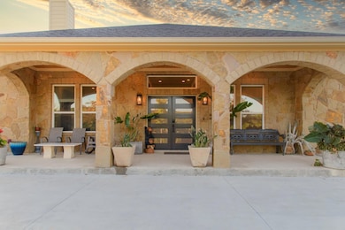 Property entrance featuring stone siding, roof wi