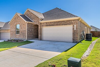 View of front of house with brick siding, concrete driveway, an attached garage, and a shingled roof