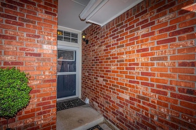 Doorway to property featuring brick siding