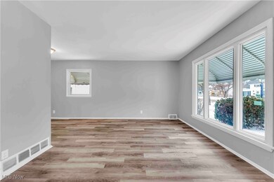 Unfurnished room with light wood finished floors, baseboards, and visible vents