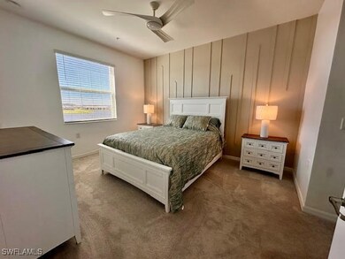 Carpeted bedroom featuring baseboards and ceiling fan