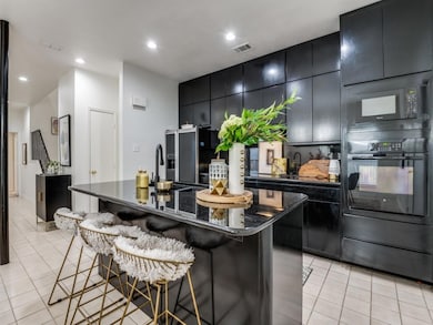 Kitchen featuring black appliances, a kitchen isla