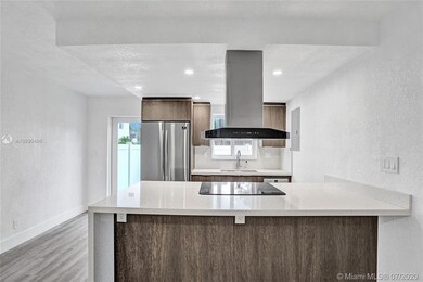Large kitchen island with overhang, electrical outlets below.