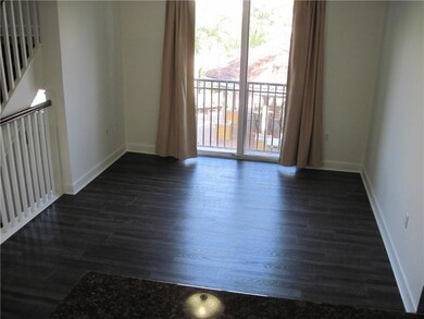 Living room w/ pool view. The flooring has recently been installed throughout and is a dark grey laminate.