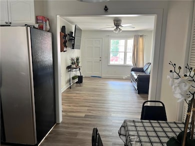 Dining area with a ceiling fan, light wood-style floors, and baseboards
