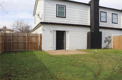 Rear view of property with brick siding, a chimney, and a fenced backyard