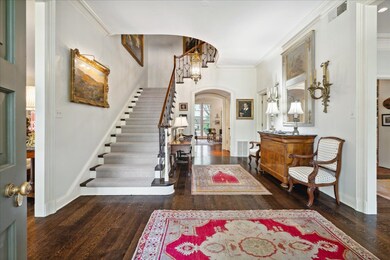 Entrance foyer with crown molding and dark wood-ty
