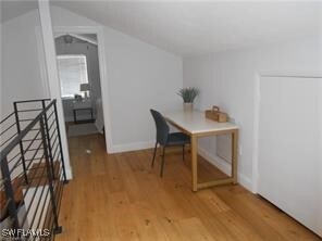 Office with hardwood / wood-style flooring and lof