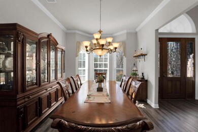 Dining area featuring crown molding, dark flooring
