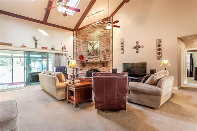 Den has high ceilings, skylights, fireplace, & wal