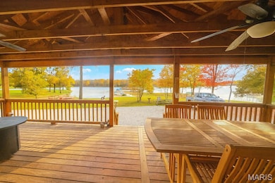 Sunroom featuring a deck with water view and ceiling fan