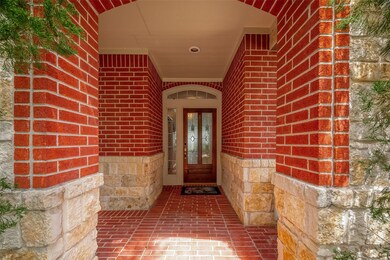 The entryway features a striking combination of rich, natural stone and warm, classic brick.