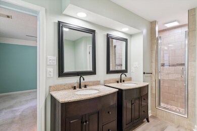 Bathroom featuring a shower with door and dual bow