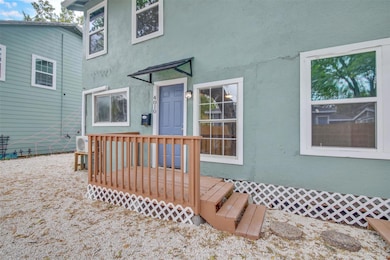 Doorway to property featuring stucco siding and a wooden deck