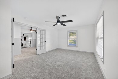 Empty room featuring light carpet and french doors