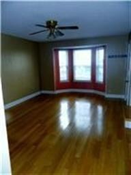 Formal living room with bay window and hard wood floors.