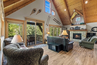 Living area featuring high vaulted ceiling, wood f