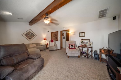 Carpeted living room featuring a textured ceiling,