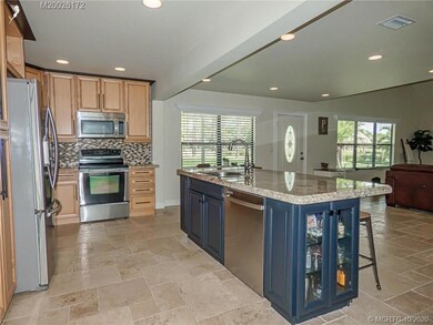 The island has lighted cabinets with glass front d