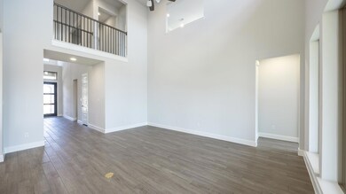 Unfurnished living room featuring a high ceiling,