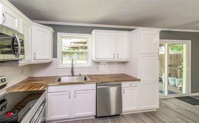Kitchen with wooden counters, backsplash, plenty o
