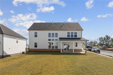 Back of house with a yard, brick siding, and roof with shingles