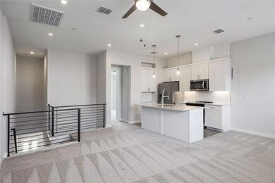Kitchen featuring light carpet, an island with si