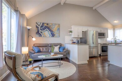Living room with beamed ceiling, dark hardwood / wood-style floors, plenty of natural light, and high vaulted ceiling