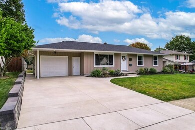 Ranch-style house featuring a front lawn and a gar