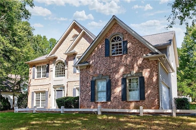 Traditional-style home with brick siding, a garage, and a front lawn